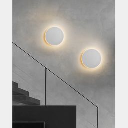 Два круглых настенных светильника на стене интерьера