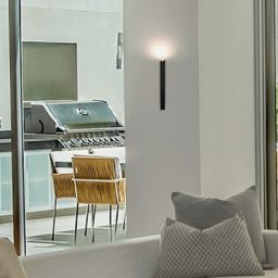 Черный настенный светильник, вертикальная установка в интерьере